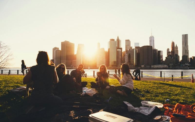 Find your perfect fit at Hubbard Place a group of people sitting on a grassy hill with a city skyline in the background