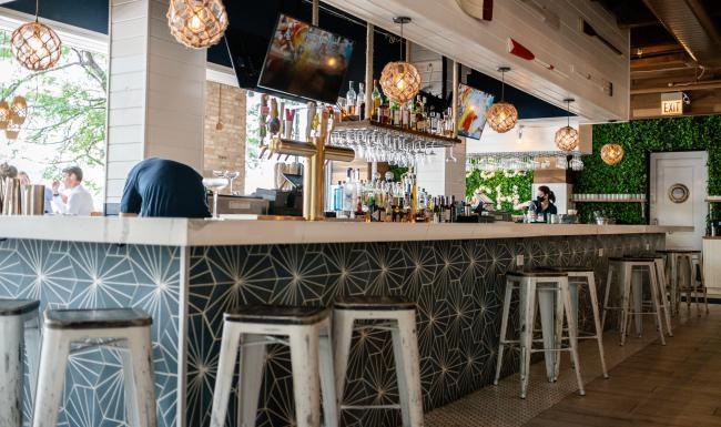a bar with stools and a tv on the wall