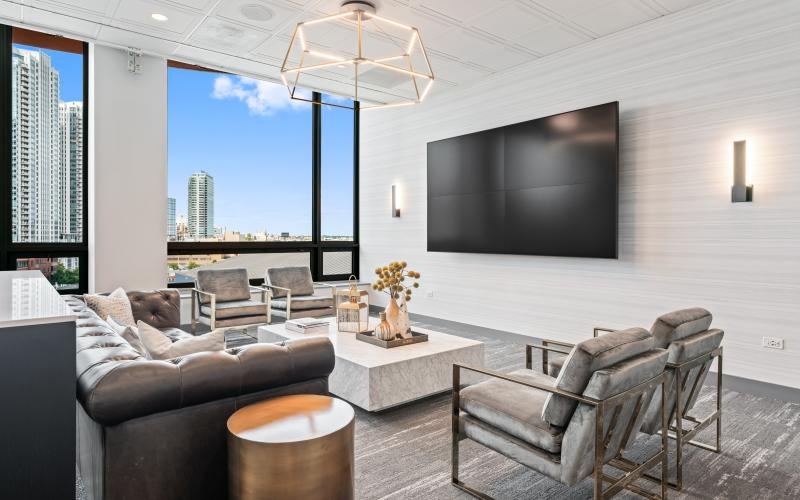 a living room with a tv and chairs