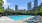 a swimming pool with lounge chairs around it and a city in the background